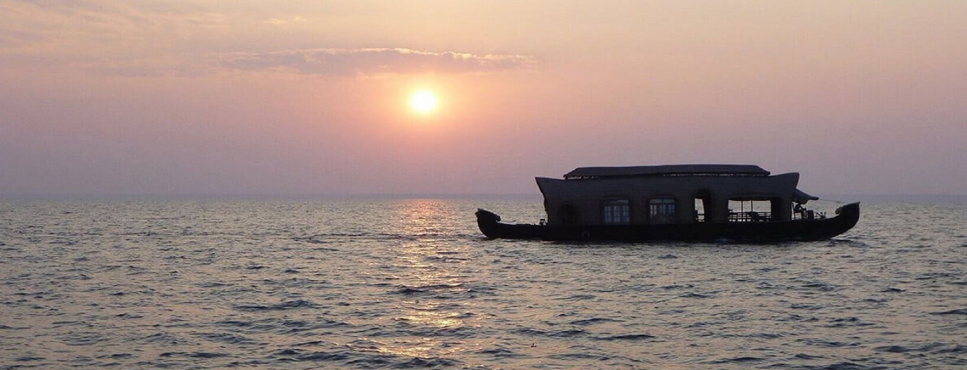Watching the sunset over Ashtamudi Lake from a boat